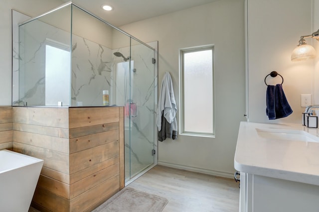3713 128th St, Lubbock, TX 79423 - bathroom featuring vanity, a marble finish shower, wood finished floors, a freestanding bath, and recessed lighting
