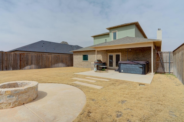 3713 128th St, Lubbock, TX 79423 - rear view of property featuring french doors, an outdoor fire pit, a hot tub, a patio area, and a fenced backyard