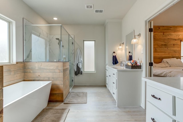 3713 128th St, Lubbock, TX 79423 - full bathroom featuring vanity, a marble finish shower, a freestanding bath, wood finished floors, and connected bathroom
