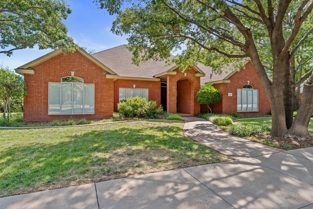 ranch-style home with a front lawn