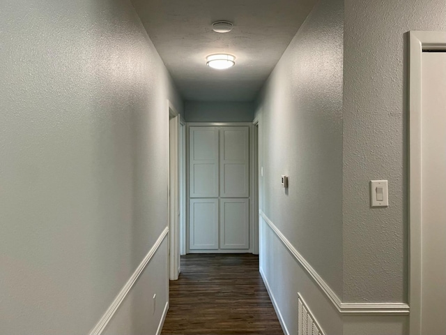 corridor with dark hardwood / wood-style flooring