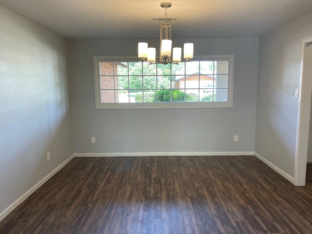 unfurnished room featuring dark wood-type flooring, a chandelier, and a healthy amount of sunlight