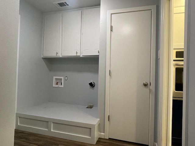 laundry area featuring cabinets, gas dryer hookup, hookup for a washing machine, and dark wood-type flooring