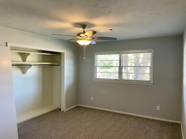 unfurnished bedroom with ceiling fan, carpet floors, a closet, and a textured ceiling