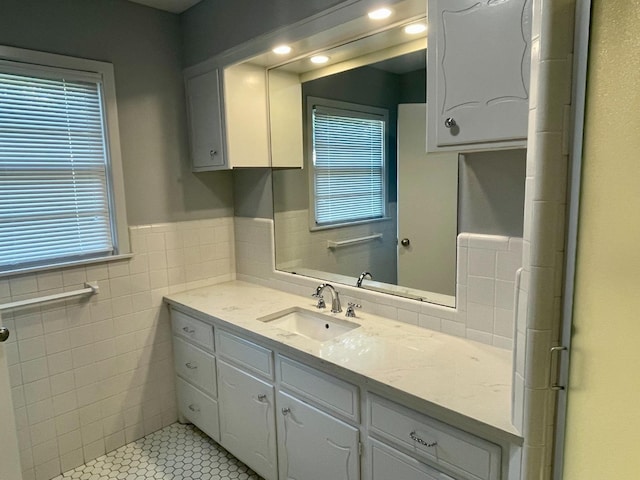 bathroom with vanity and tile walls