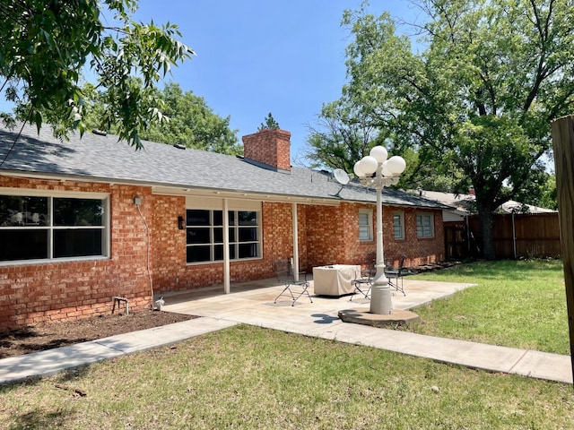 rear view of house featuring a patio area and a lawn