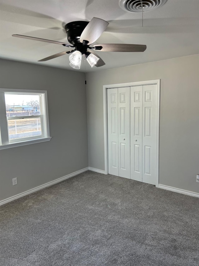 unfurnished bedroom featuring carpet, ceiling fan, and a closet