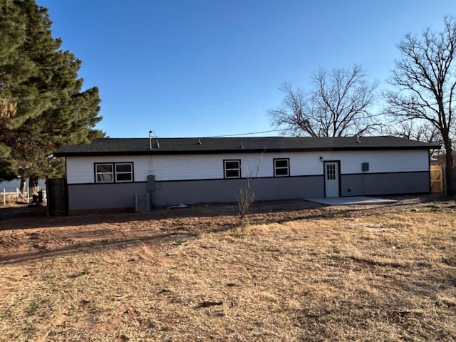 rear view of property featuring a yard, central AC unit, and a patio area