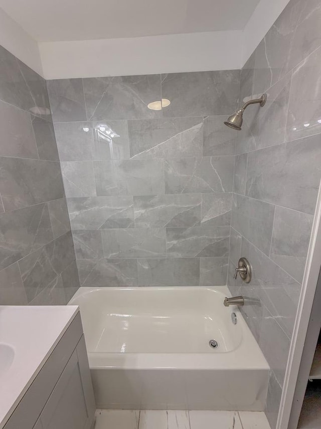 bathroom featuring tiled shower / bath combo and vanity