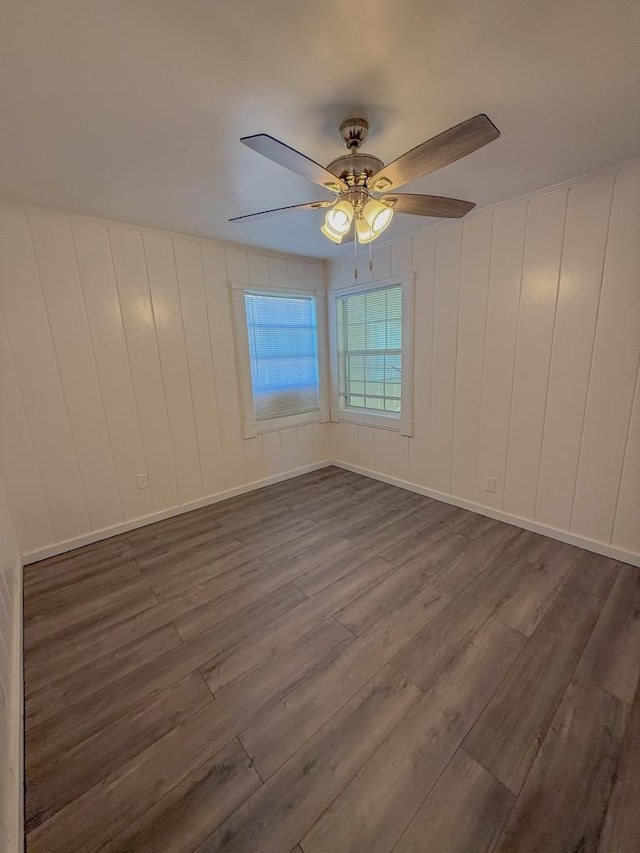 unfurnished room with ceiling fan and dark hardwood / wood-style flooring