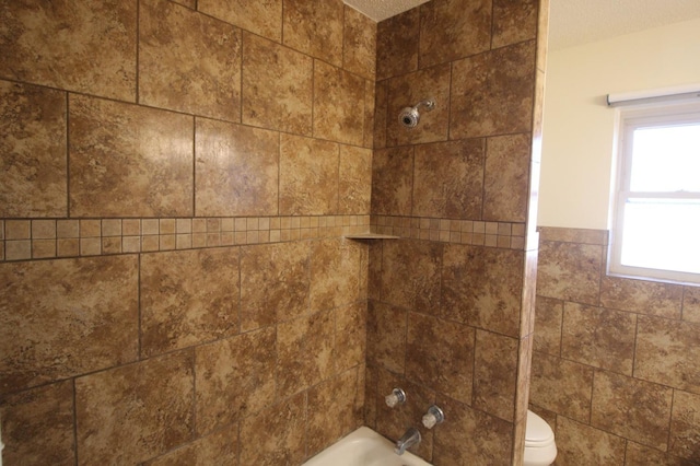 details featuring tiled shower / bath combo and toilet