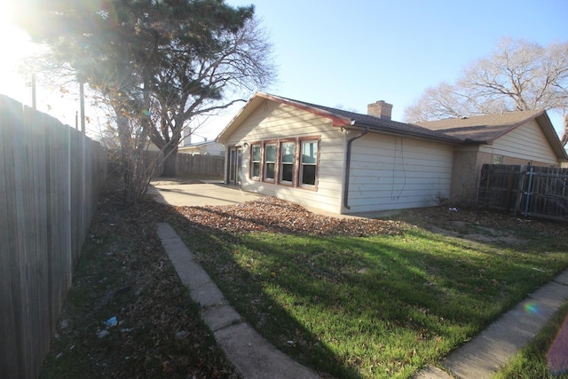 view of side of property featuring a yard and a patio area