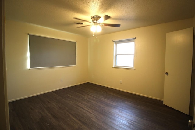 unfurnished room with ceiling fan, dark wood-type flooring, and a textured ceiling