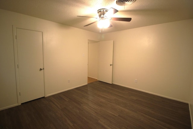 unfurnished room featuring ceiling fan, a textured ceiling, and dark hardwood / wood-style flooring