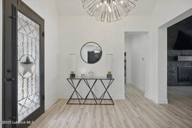 9105 Kewanee Ave, Lubbock, TX 79424 - entryway with wood finished floors, a chandelier, baseboards, and a stone fireplace