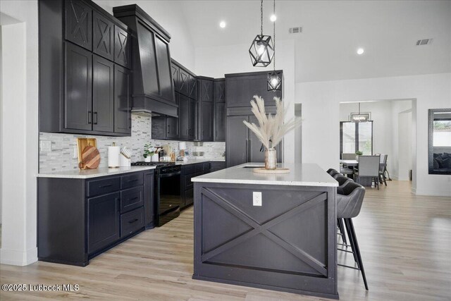 9105 Kewanee Ave, Lubbock, TX 79424 - kitchen featuring black gas range oven, a center island, light countertops, a kitchen breakfast bar, and recessed lighting