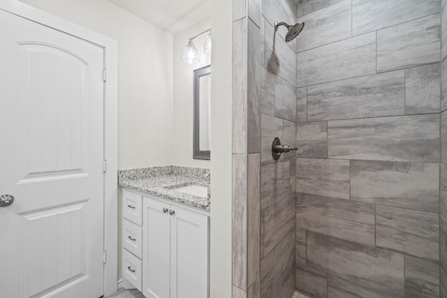 bathroom with vanity and tiled shower