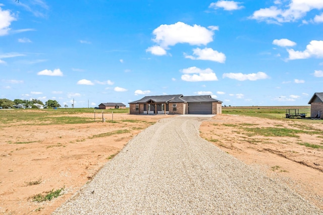 ranch-style house featuring a rural view and a garage