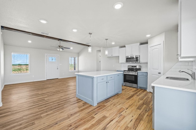 kitchen with sink, pendant lighting, stainless steel appliances, decorative backsplash, and white cabinets