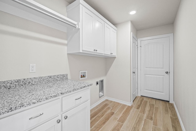 clothes washing area with cabinets, hookup for a washing machine, hookup for an electric dryer, and light hardwood / wood-style floors