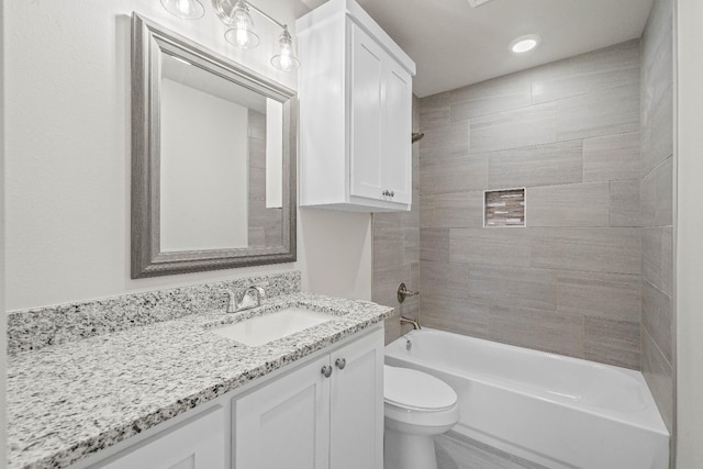 full bathroom with tiled shower / bath, vanity, and toilet