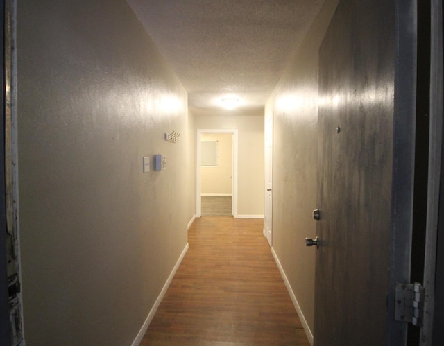 hall featuring hardwood / wood-style flooring and a textured ceiling