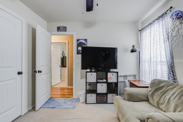 carpeted living room with ceiling fan