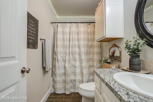 7204 90th St, Lubbock, TX 79424 - full bath with toilet, vanity, wood tiled floors, baseboards, and a shower with shower curtain