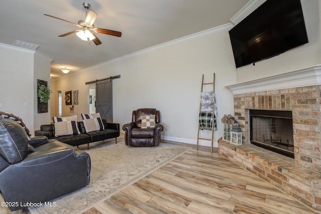 7204 90th St, Lubbock, TX 79424 - living area with ornamental molding, ceiling fan, a barn door, wood finished floors, and baseboards