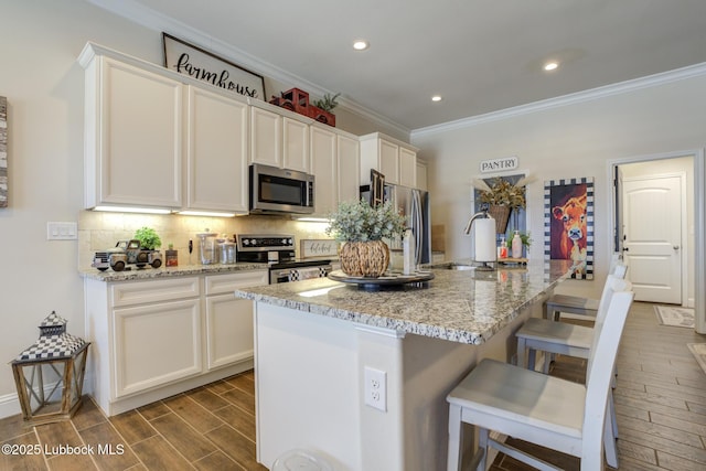 7204 90th St, Lubbock, TX 79424 - kitchen with appliances with stainless steel finishes, crown molding, tasteful backsplash, dark wood-style floors, and a breakfast bar area