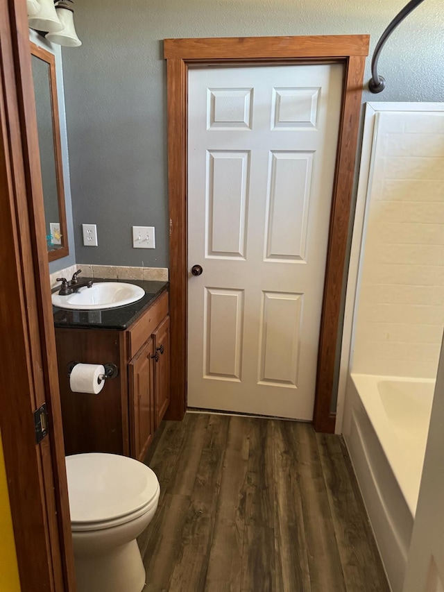 full bathroom featuring hardwood / wood-style flooring, vanity, toilet, and bathtub / shower combination