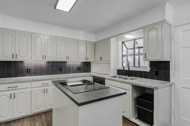 kitchen with white cabinetry, sink, black electric stovetop, and a kitchen island