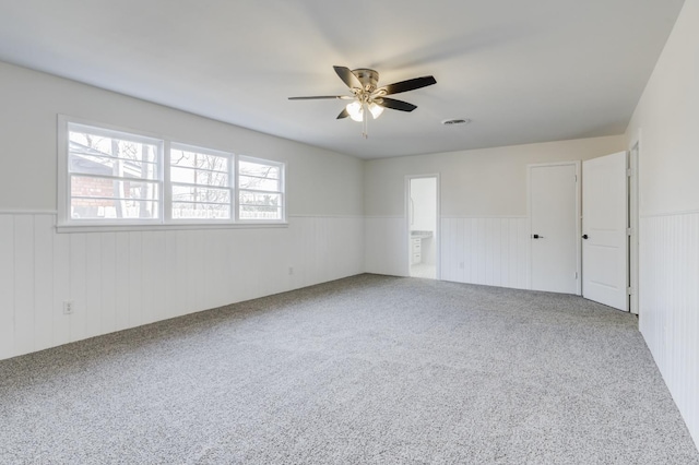 unfurnished room featuring ceiling fan and carpet