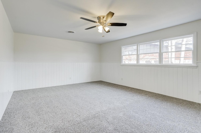 spare room with ceiling fan and carpet