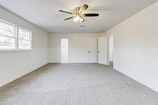 carpeted spare room with ceiling fan