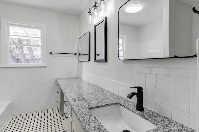 bathroom featuring tile patterned floors, vanity, tile walls, and a wealth of natural light