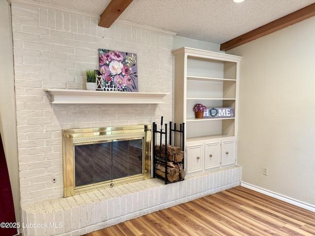 5508 94th St, Lubbock, TX 79424 - detailed view of beamed ceiling, a brick fireplace, wood finished floors, baseboards, and a textured ceiling