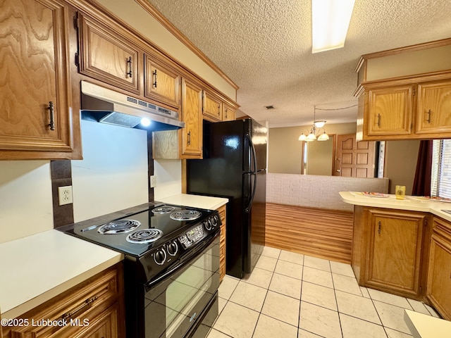 5508 94th St, Lubbock, TX 79424 - kitchen featuring under cabinet range hood, black appliances, light countertops, brown cabinetry, and a textured ceiling