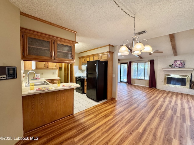 5508 94th St, Lubbock, TX 79424 - kitchen with black appliances, a sink, light wood-type flooring, open floor plan, and a chandelier