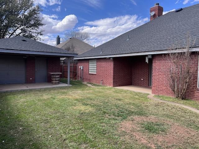 view of yard featuring a garage and a patio area