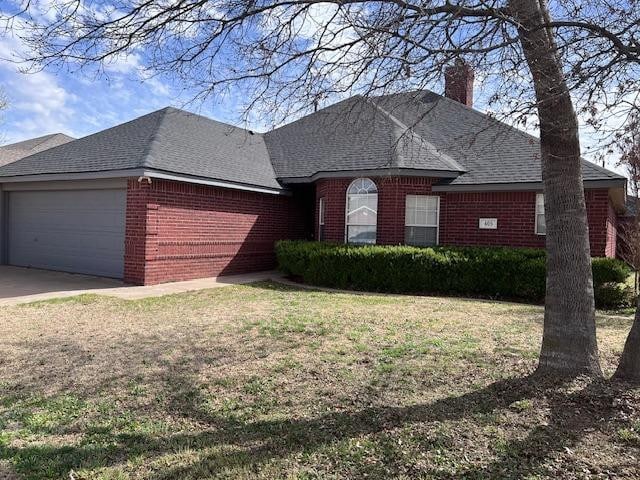 ranch-style home featuring a garage and a front lawn