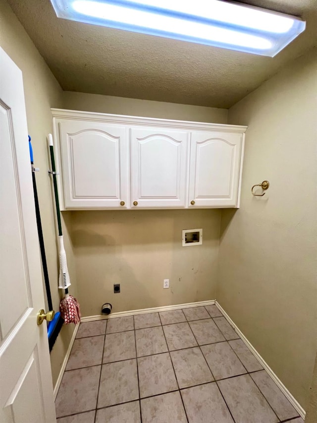 clothes washing area featuring cabinets, washer hookup, light tile patterned floors, electric dryer hookup, and a textured ceiling