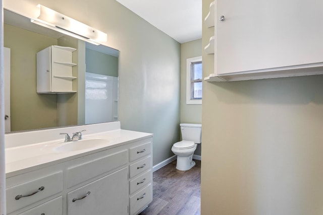 bathroom featuring vanity, hardwood / wood-style flooring, and toilet