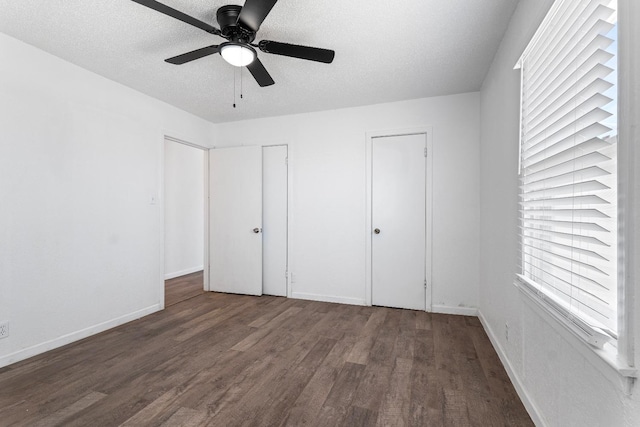 unfurnished bedroom with ceiling fan, a textured ceiling, and dark hardwood / wood-style flooring