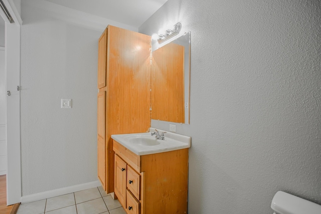 bathroom with tile patterned flooring, vanity, and toilet