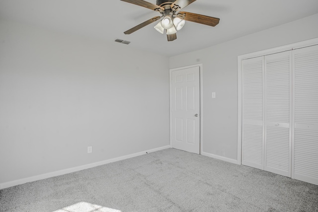 unfurnished bedroom featuring ceiling fan, carpet flooring, and a closet