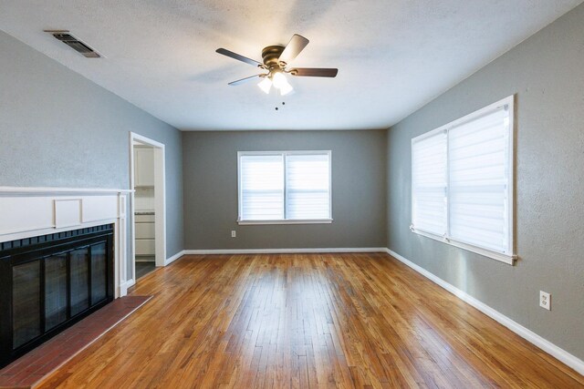 unfurnished living room with ceiling fan and hardwood / wood-style floors