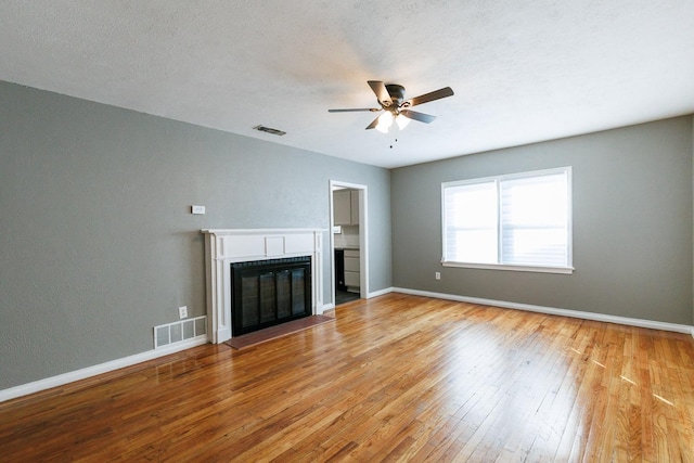 unfurnished living room featuring a textured ceiling, light hardwood / wood-style flooring, and ceiling fan