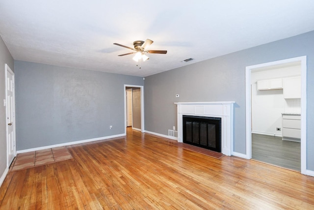 unfurnished living room with ceiling fan and light wood-type flooring