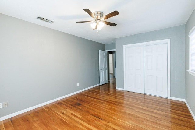 unfurnished bedroom featuring light wood-type flooring, ceiling fan, and a closet